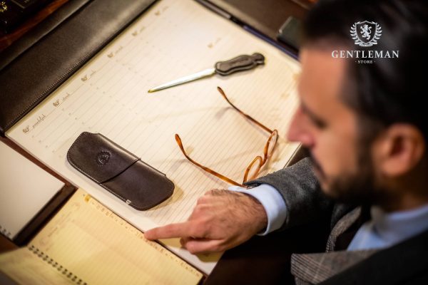 Ovaj predmet je ručno izrađen od metalnih elemenata koji su obloženi kvalitetnom goveđom kožom i postavljeni sa čojom. Kada je prazan i sklopljen, zauzima malo prostora u torbi ili na stolu, a kada se nalaze naočale u njemu, čvrst materijal pruža zaštitu. Pogodan je za naočale za sunce. Na artiklu i luksuznom pakovanju utisnut je logo našeg brenda "Gentleman".